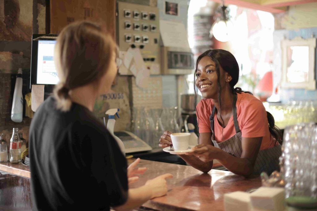 a shop owner with smile on her face showing the importance of Body Language for Customer Service