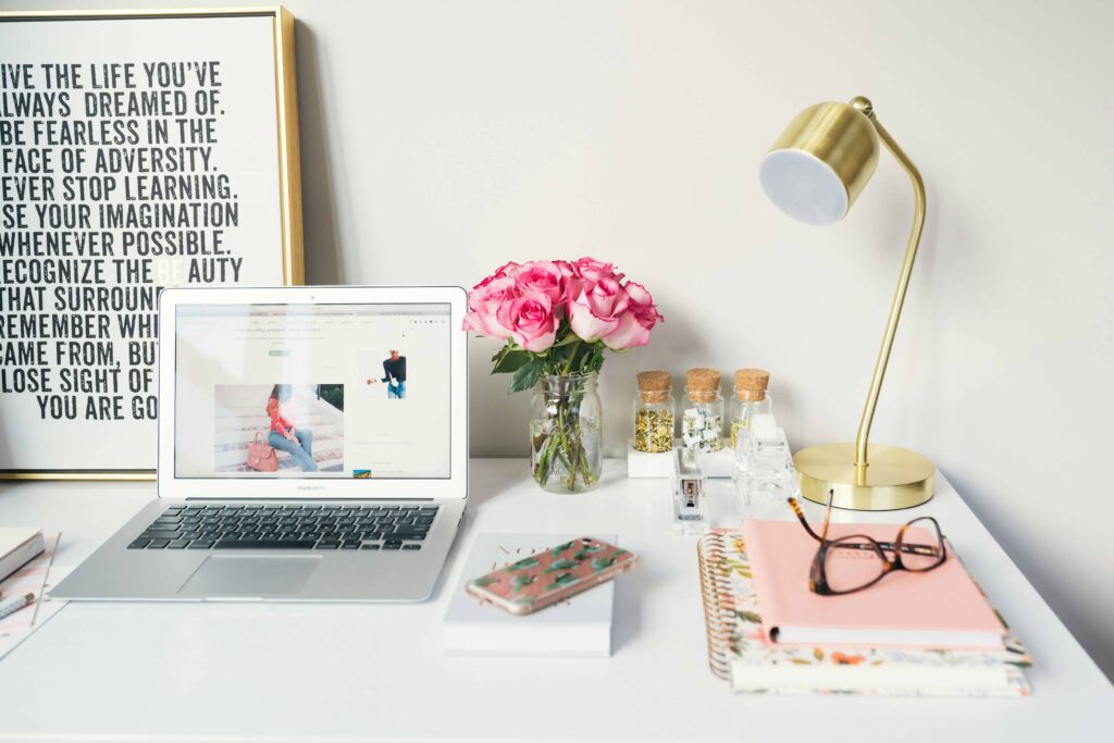 image of a laptop on desk with a lamo and white background