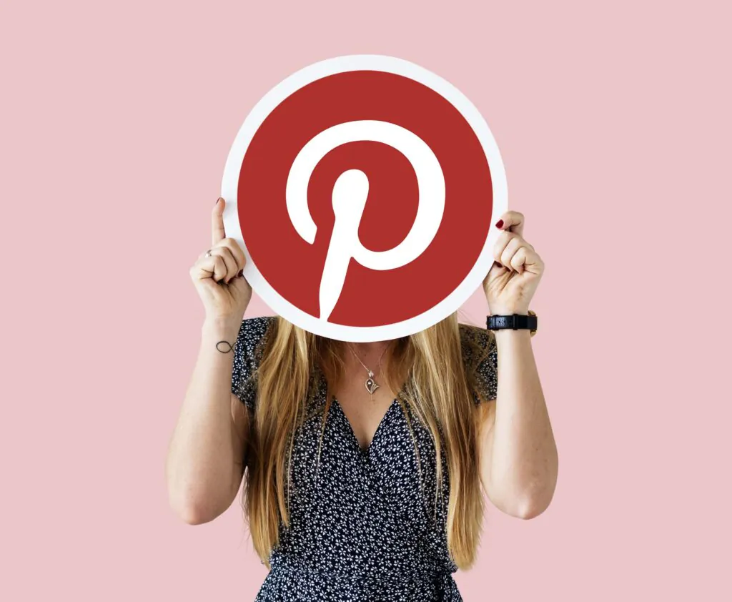 girl holding a circular Pinterest logo in hand